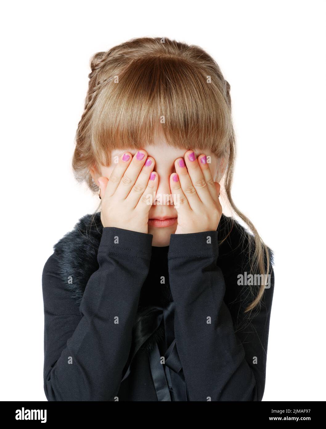 Little girl covers her face with hands on a white background Stock Photo