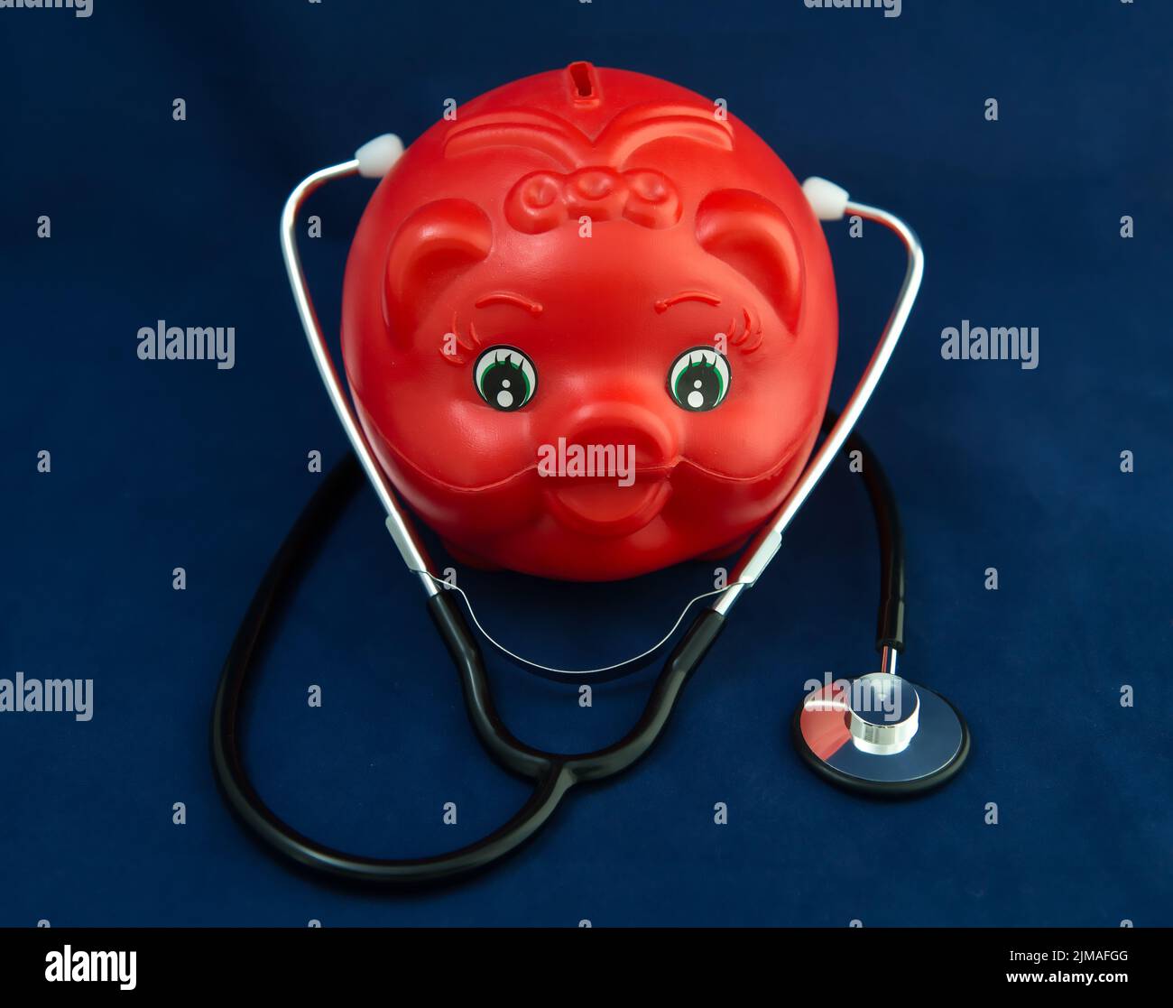 Piggy Bank and Stethoscope with Selective Focus on a blue Background. Stock Photo