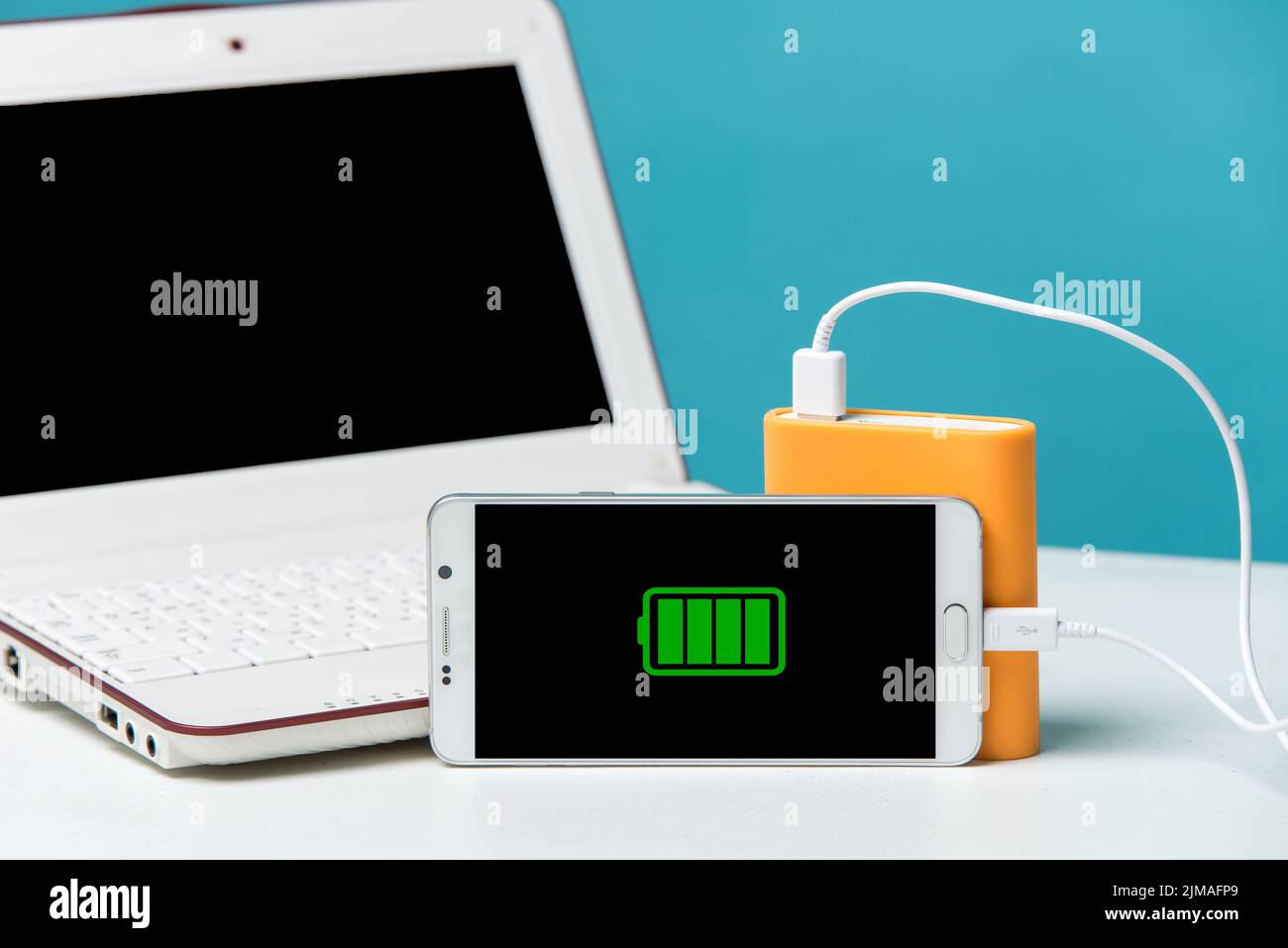 Full charge of a smartphone on its monitor with the cable connected to the special power bank. Stock Photo
