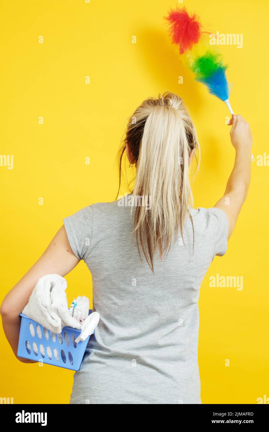 dust cleaning woman backview feather duster cloths Stock Photo