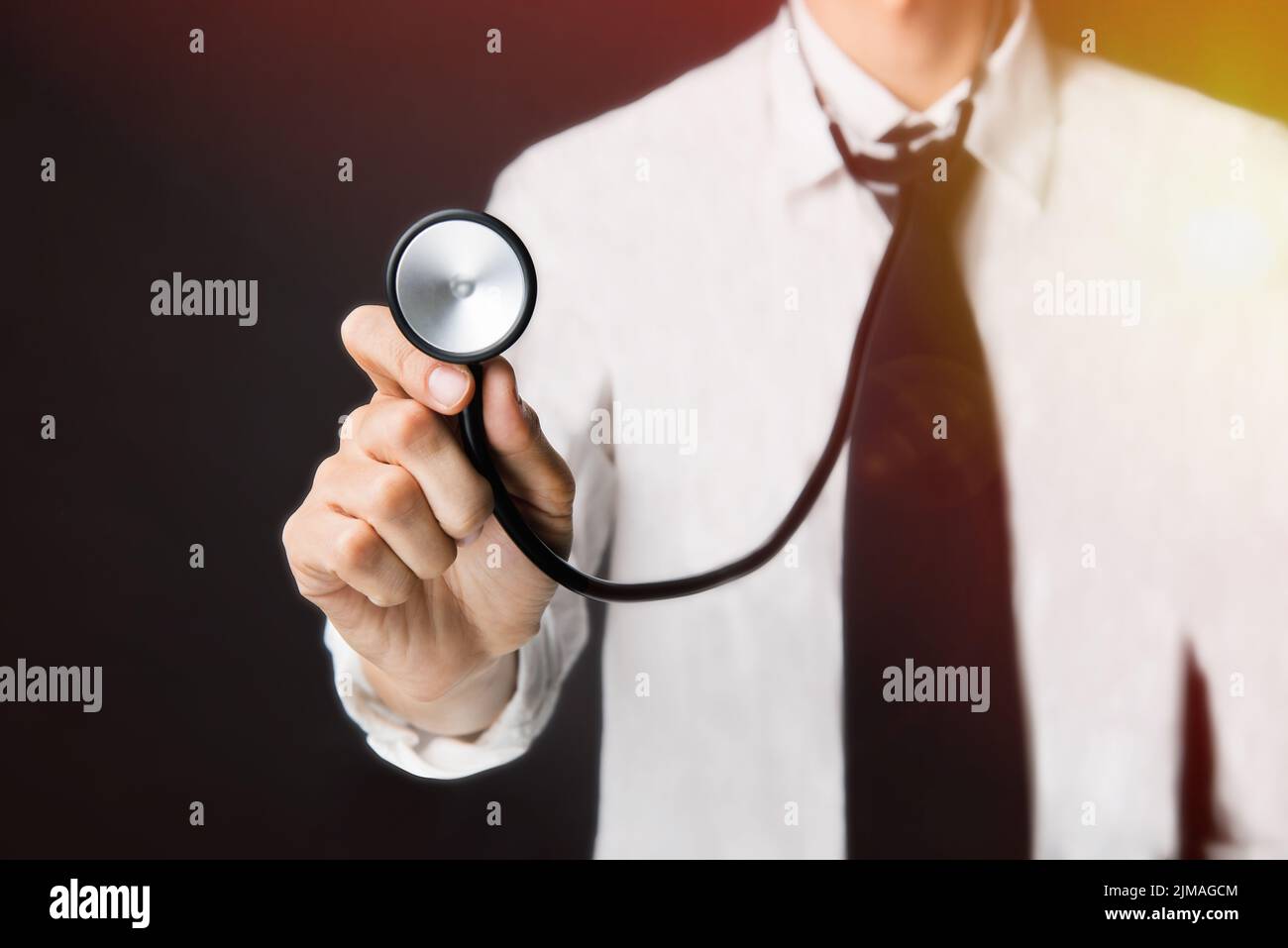 With the back light, Doctor with a stethoscope in the hands on black background Stock Photo