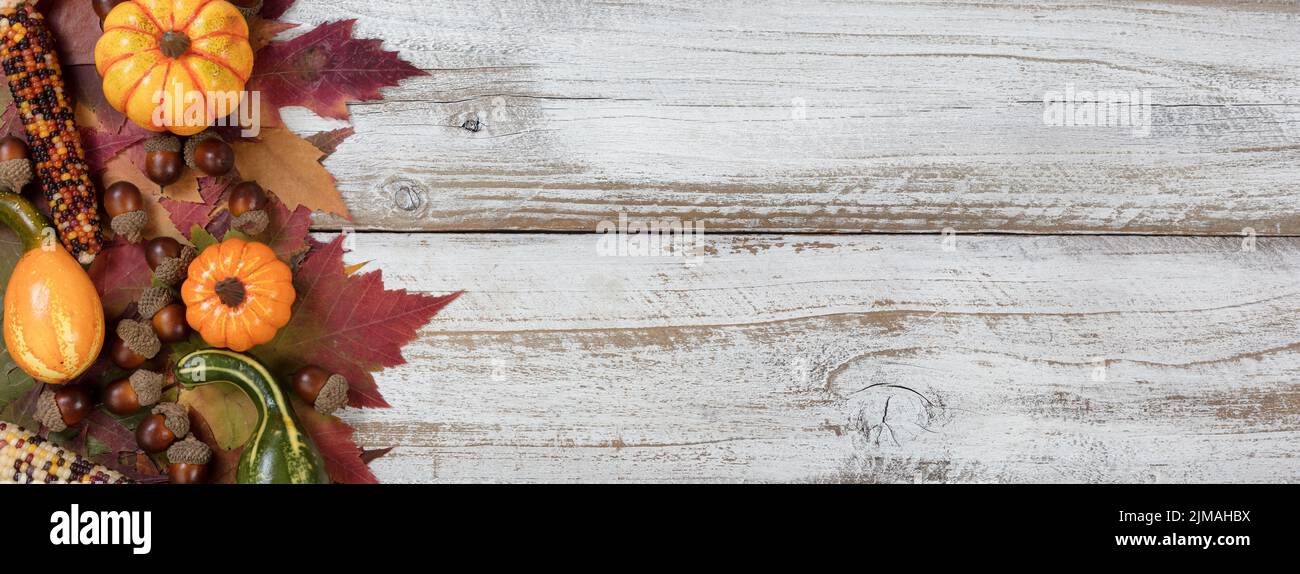 Autumn foliage with other fall decorations on white rustic wooden boards Stock Photo