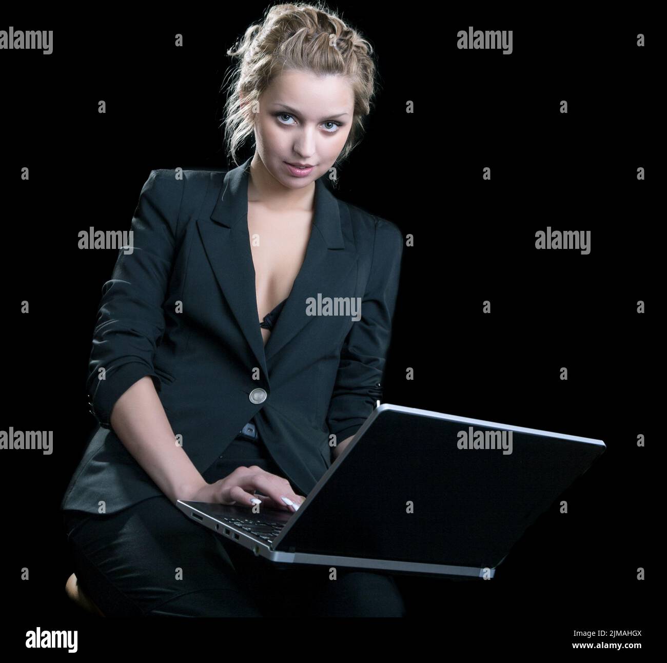 Girl in a business suit with the laptop on  black background Stock Photo
