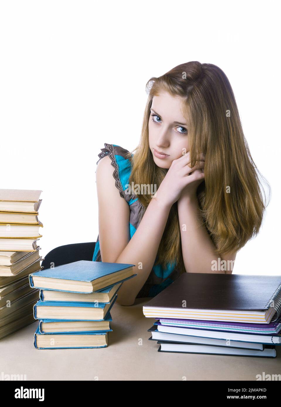 The girl with pile of books and writing-books on a white background Stock Photo