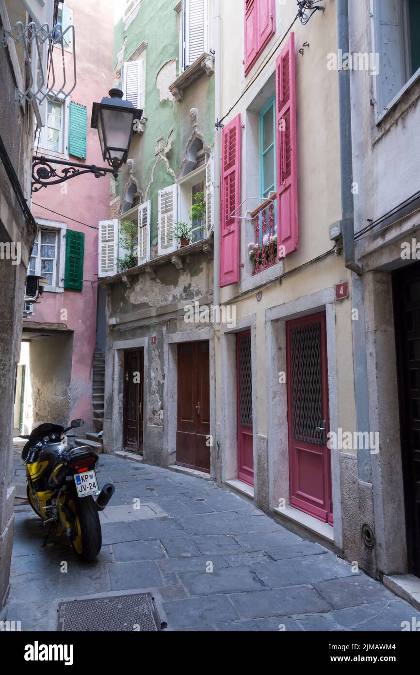 Parked motorcycle in a narrow picturesque street in the historic center of Piran. Slovenia. Stock Photo