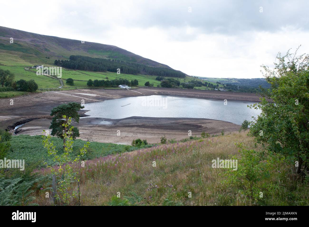 UK Weather 5.8.2022 Dovestone Reservoir Greenfield Saddleworth UK The lack of rainfall over recent weeks has left Dovestone Reservoir at an alarmingly low level of water revealing rocks that are usually unseen. Credit: Peter Liggins/Alamy Live News Stock Photo