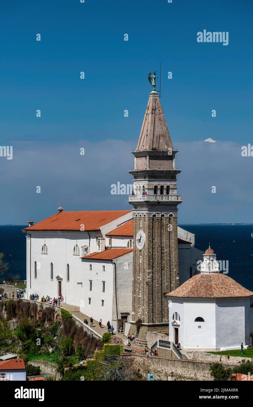 Beautiful city of Piran with St. George Church on a warm, sunny eastertime day against deep blue sky. Stock Photo