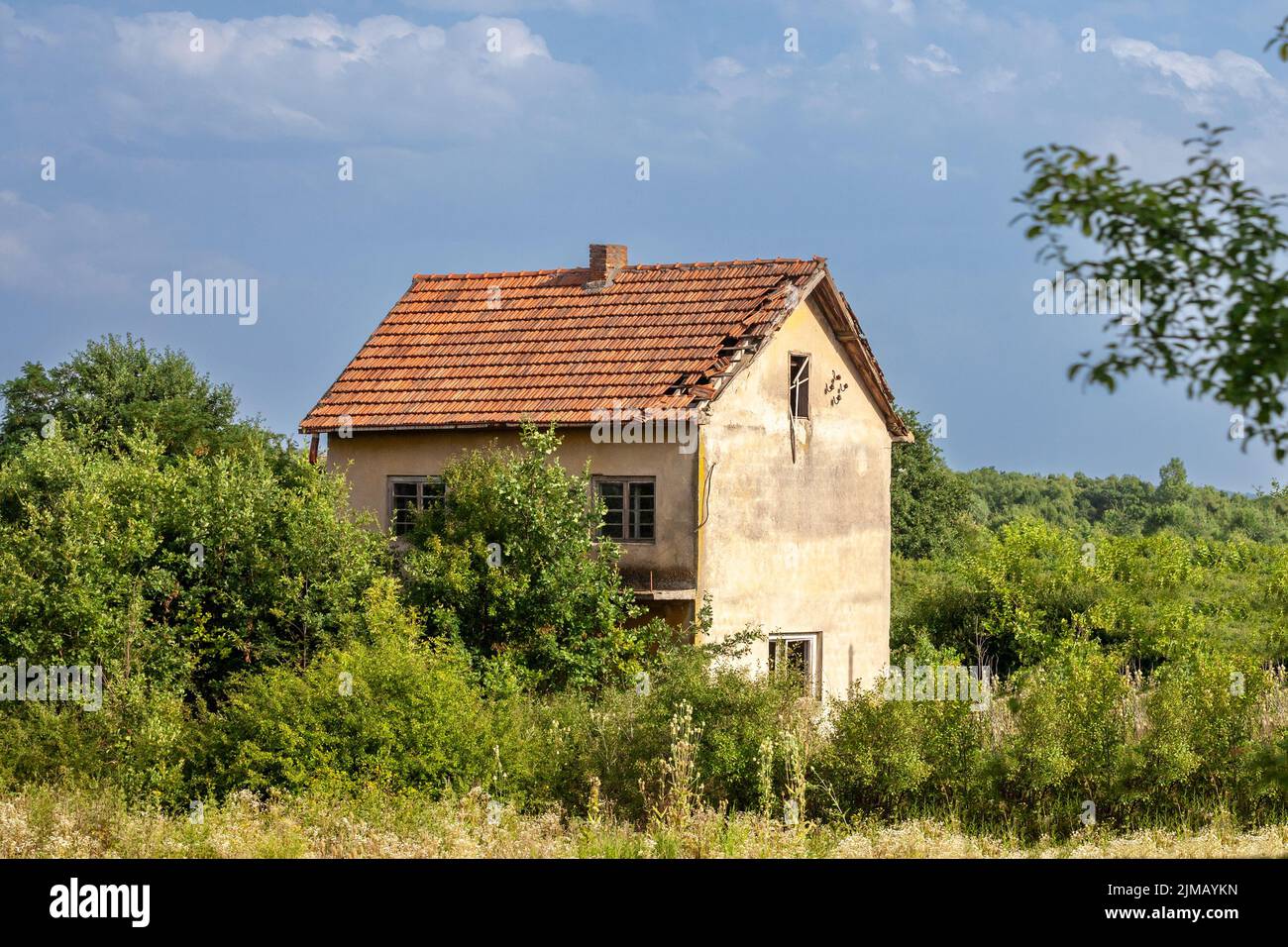 Picture of an abandoned farm in Serbia, with the facade of its main house heavily damaged in a region hit with demographic decline and rural exodus. Stock Photo