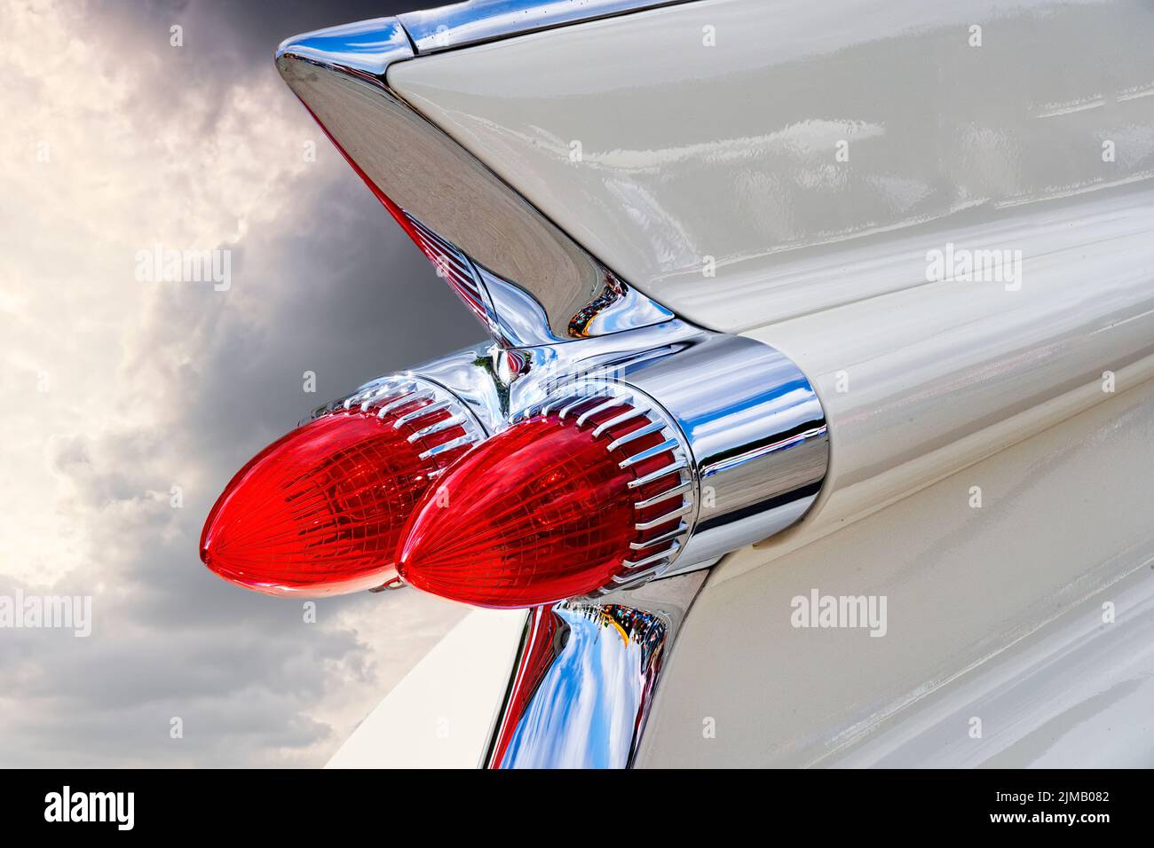 Red conical tail lights on the white fin on the stern of an American classic road cruiser Stock Photo