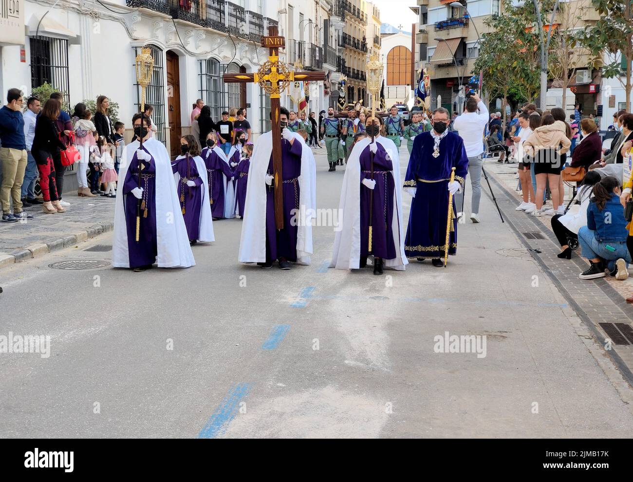 COIN SPAIN - APRIL 2022. Tourist walking in the Catholic procesion of holy week in a sunny day. Stock Photo