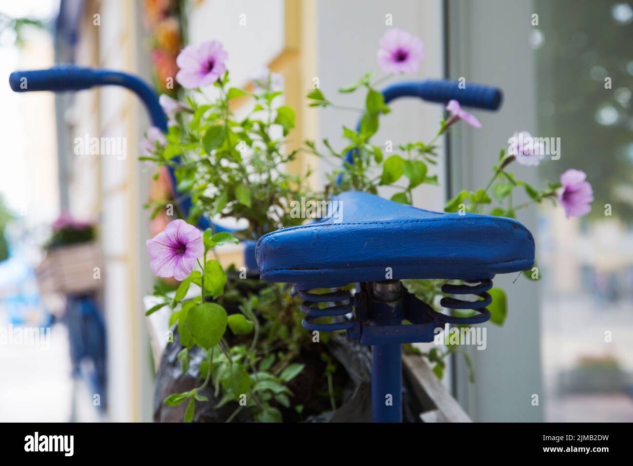 Old bicycle with flowers on the city street Stock Photo