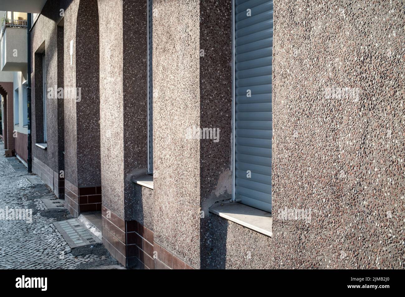Clean walls and shuttered doors and windows on a sunny afternoon in the Neukölln area of Berlin, Germany. Stock Photo