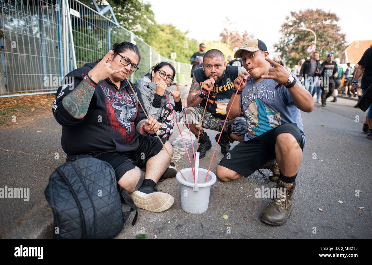 Wacken, Germany. 05th Aug, 2022. Festival-goers drink alcohol from a bucket on the sidelines of the Wacken Open Air Festival. The WOA is considered the largest heavy metal festival in the world. Credit: Daniel Reinhardt/dpa/Alamy Live News Stock Photo