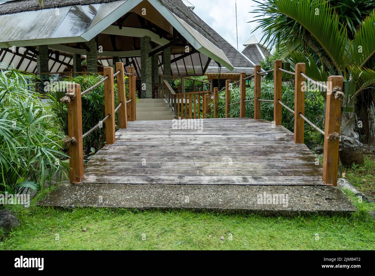 A view of a wooden bridge in a park with green plants Stock Photo - Alamy