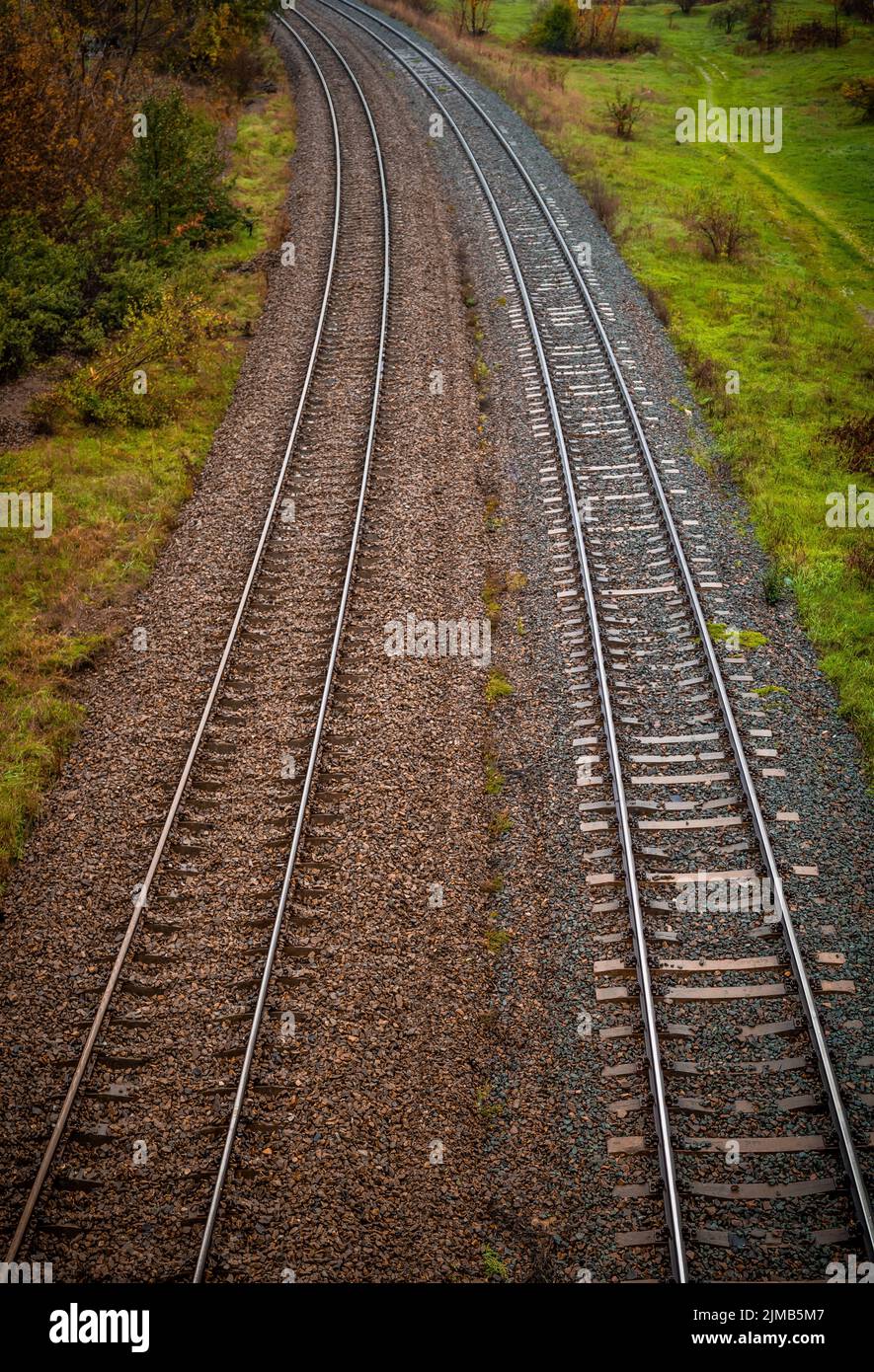 A vertical high angle of two train railways covered with different ...