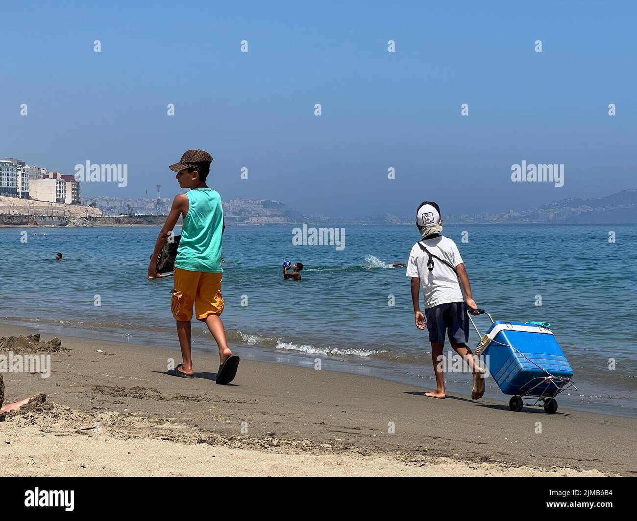 Young kid pushes a food box behind him on the beach Stock Photo Alamy