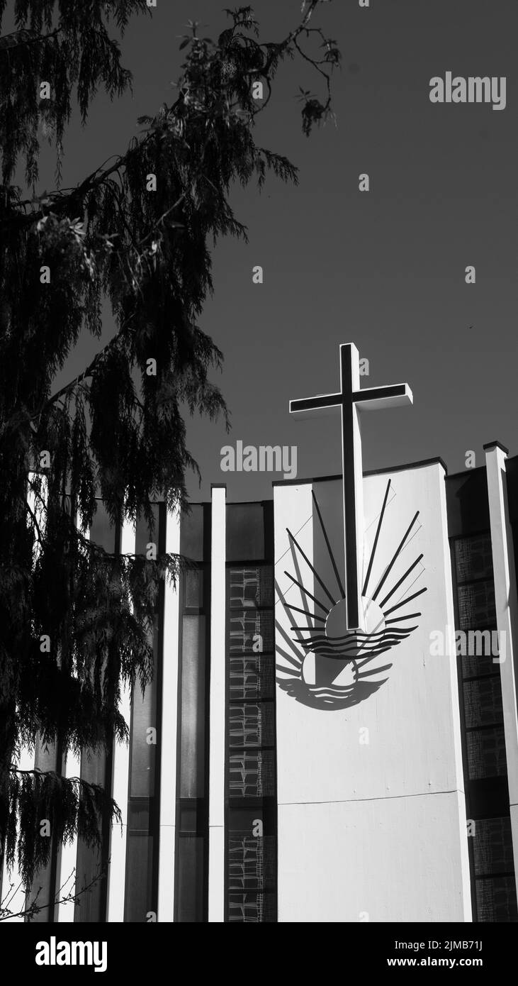 A vertical of a cross on a Lutheran church shot in grayscale Stock ...