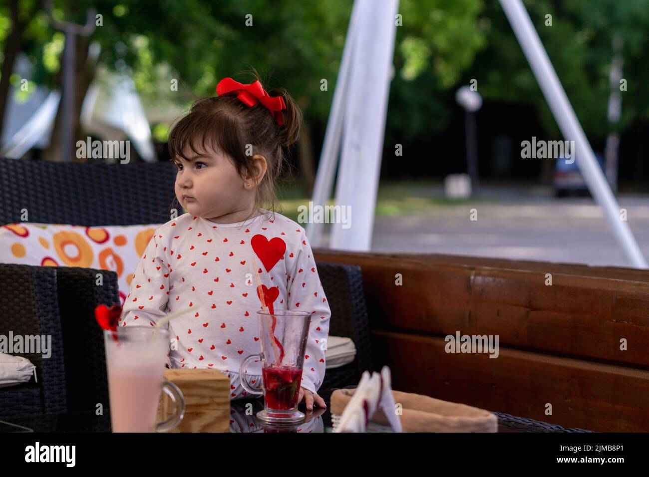 The little girl in a cafe looking to the right. Stock Photo