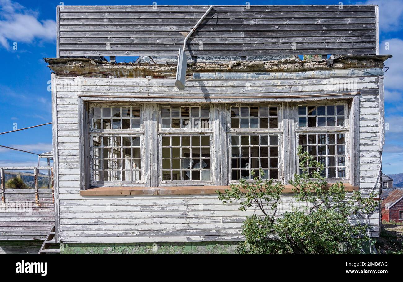 Close up of derelict wooden building in abandoned mining town with peeling paint and broken windows in Ivittuut, Greenland on 21 July 2022 Stock Photo