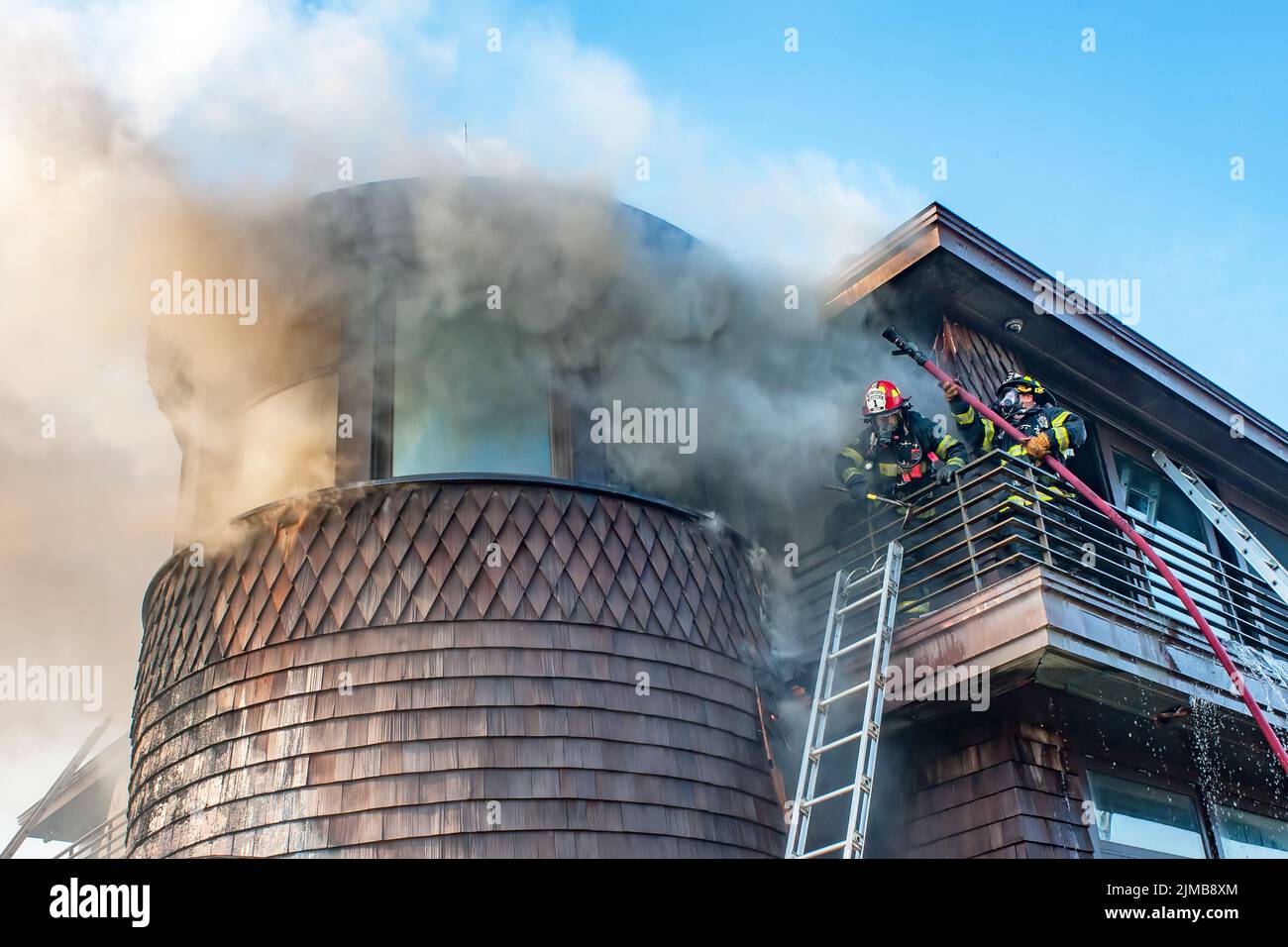 Bridgehampton, New York firefighters were aided by firefighters from several other departments as they fought a stubborn fire in a modern house at 187 Stock Photo