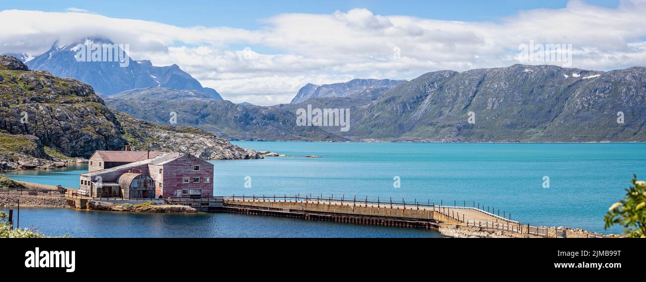Panoramic landscape of abandoned mining building and surrounding mountains in Ivittuut, Greenland on 21 July 2022 Stock Photo