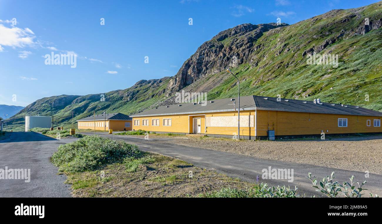 Boarded up yellow buildings at the small Danish military base at Grondalen, West Greenland on 21 July 2022 Stock Photo