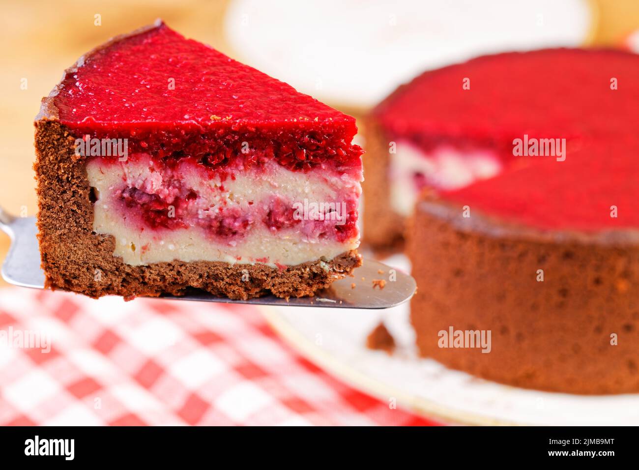 Closeup piece of homemade raspberry and strawberry cheesecake. Shallow focus. Stock Photo
