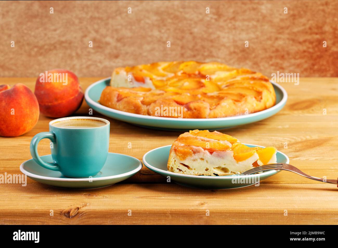 Homemade pie with peaches and cup of coffee espresso on wooden table. Shallow focus. Stock Photo