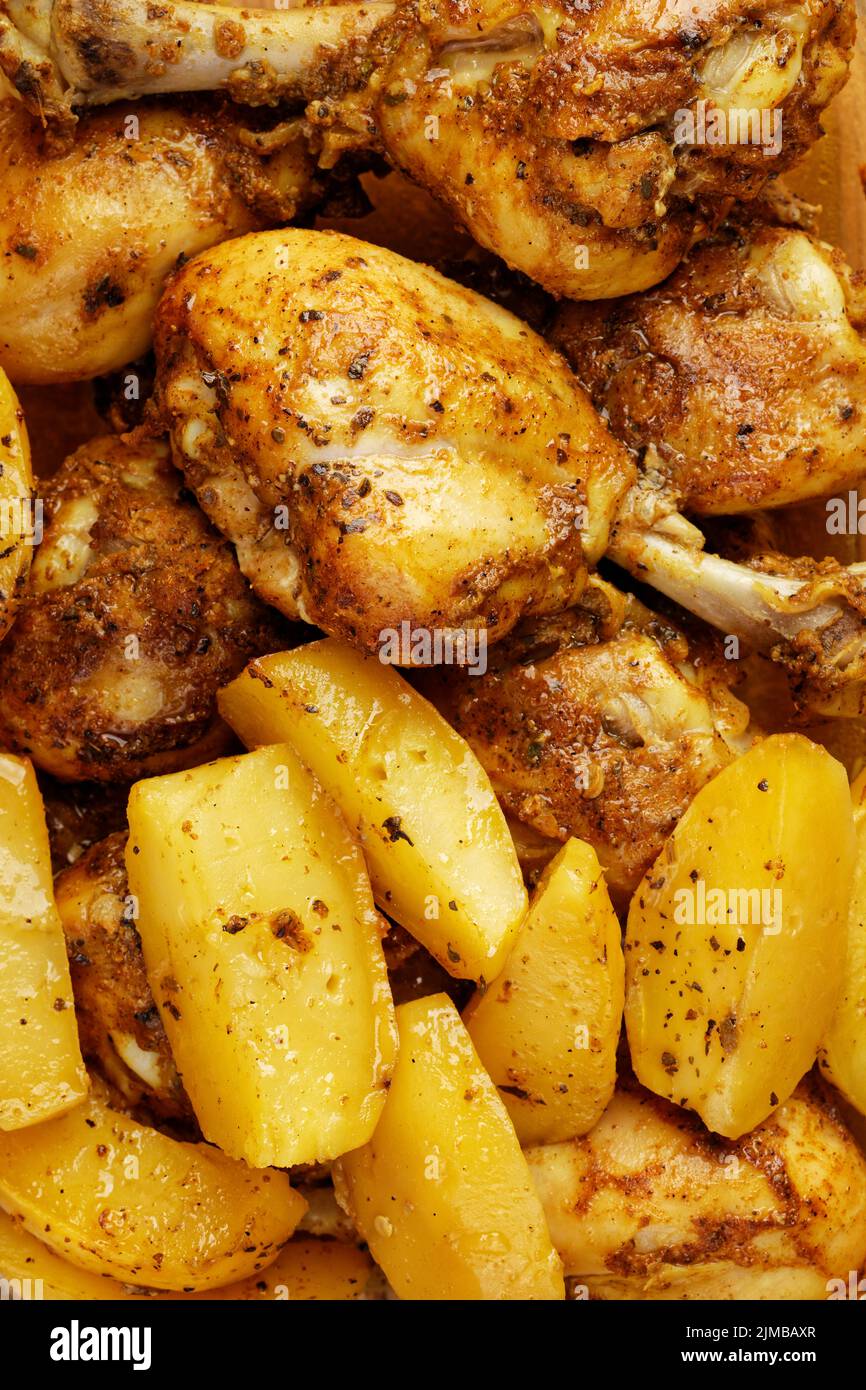 Roasted chicken legs and baked potatoes. Close up view. Stock Photo