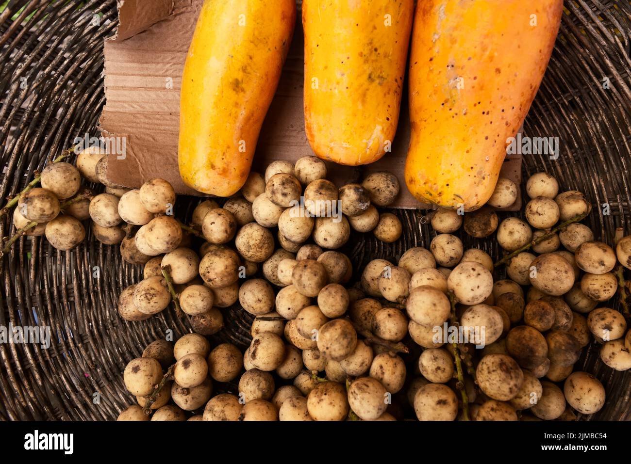Basket of longans and papayas Stock Photo