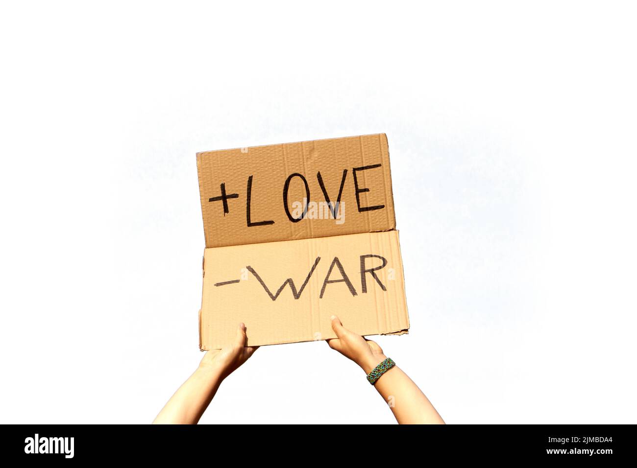 A Cardboard Signs saying More Love, Less War held by two hands a white background ready for montage Stock Photo