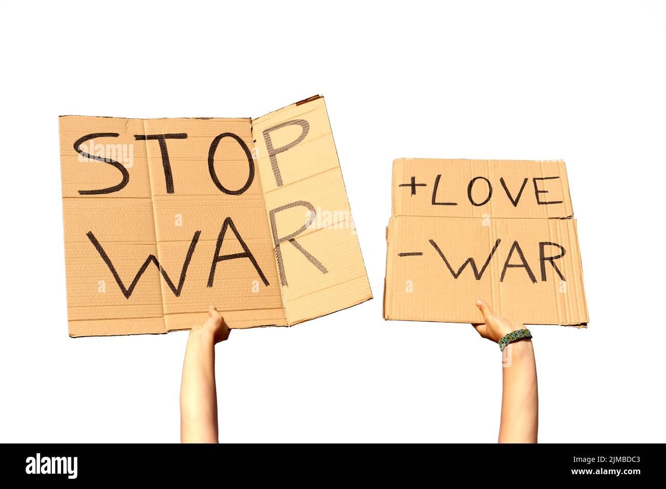 Two Cardboard Signs saying more love, less war and Stop War held by hands on a white background ready for montage Stock Photo