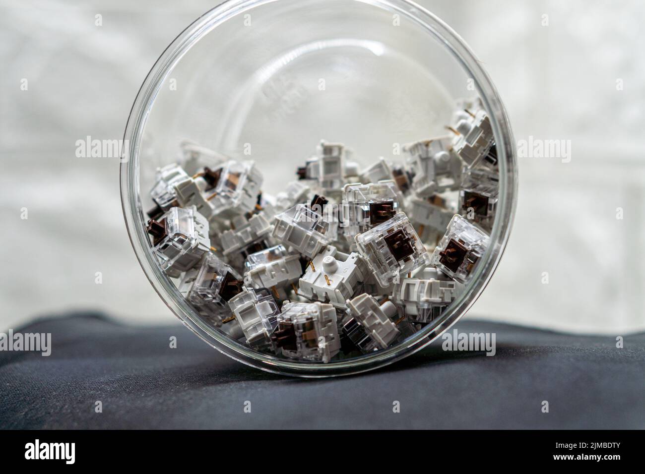 A closeup of mechanical keyboard switches piled in a transparent jar