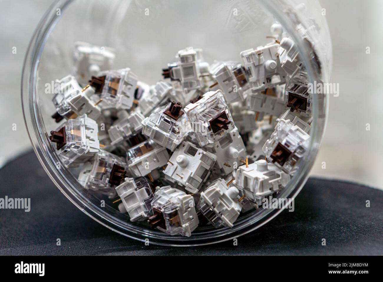 A closeup of mechanical keyboard switches piled in a transparent jar