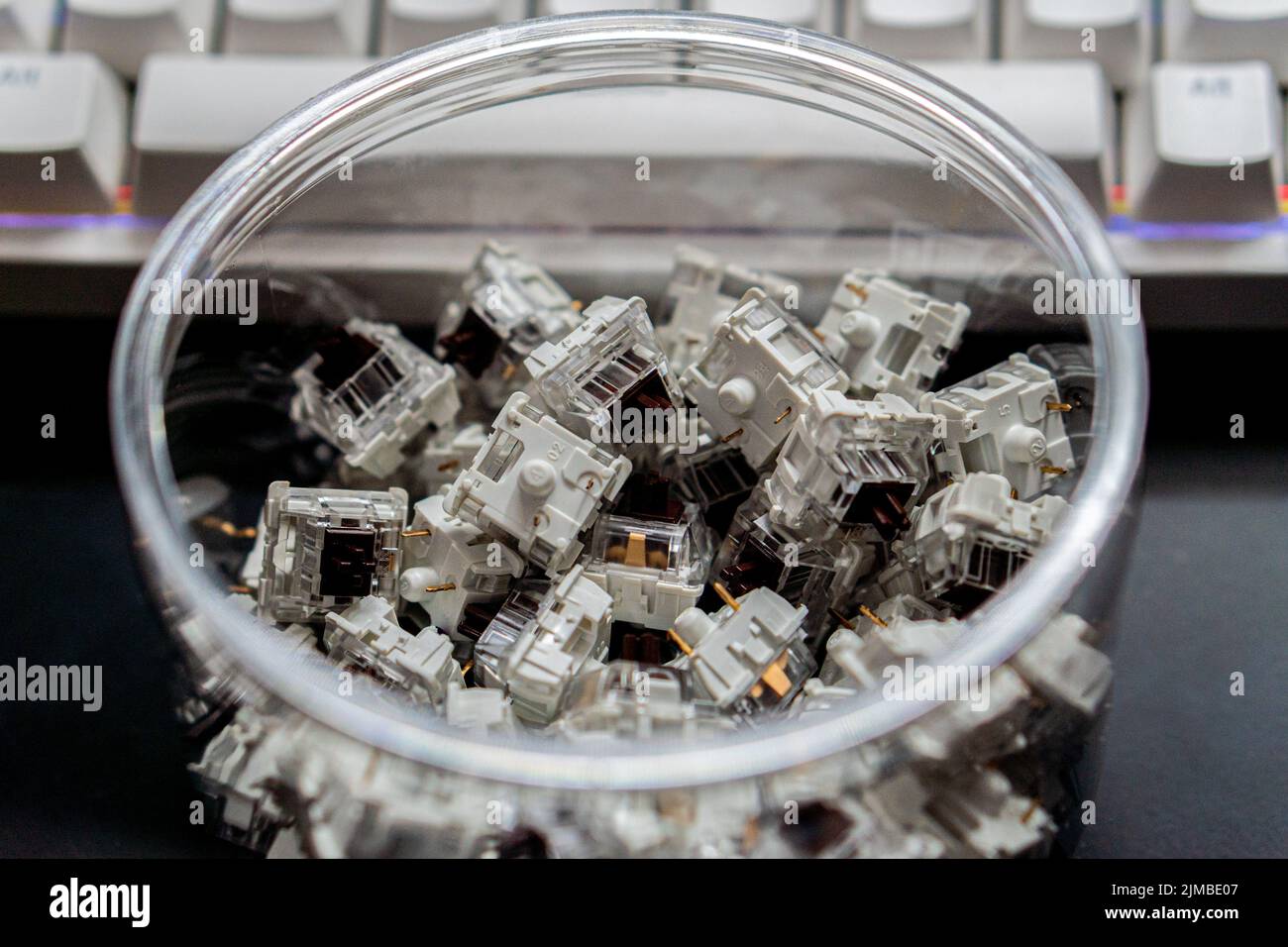A closeup of mechanical keyboard switches piled in a transparent jar