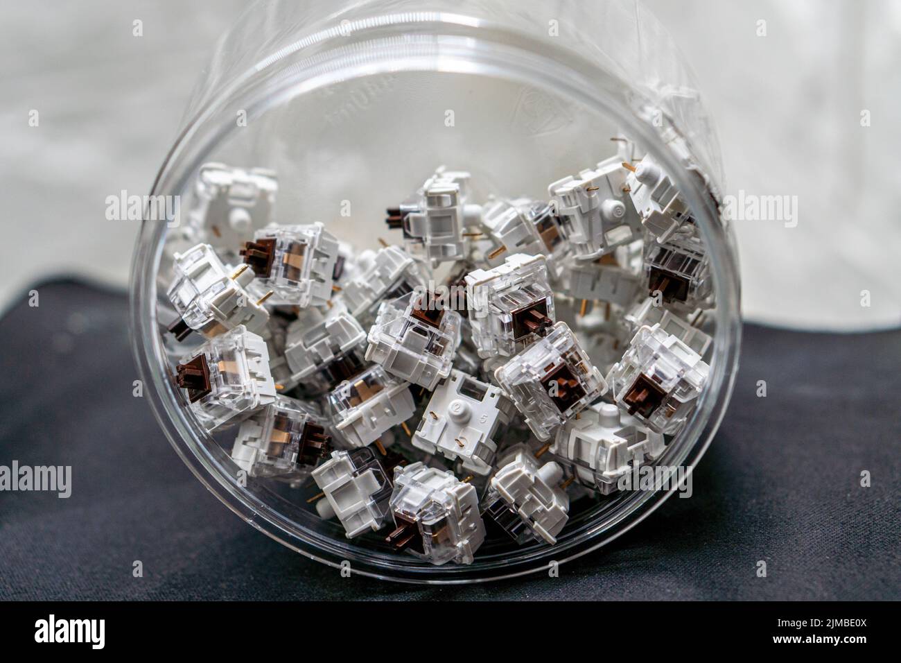A closeup of mechanical keyboard switches piled in a transparent jar