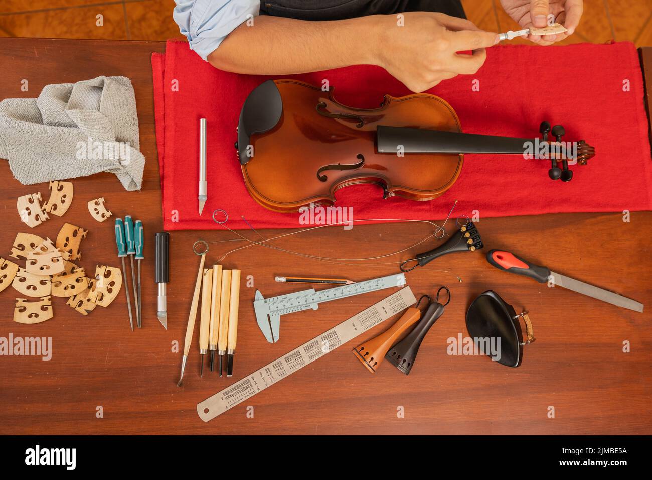 Top view of a table with set of tools to repair a violin and a raw of