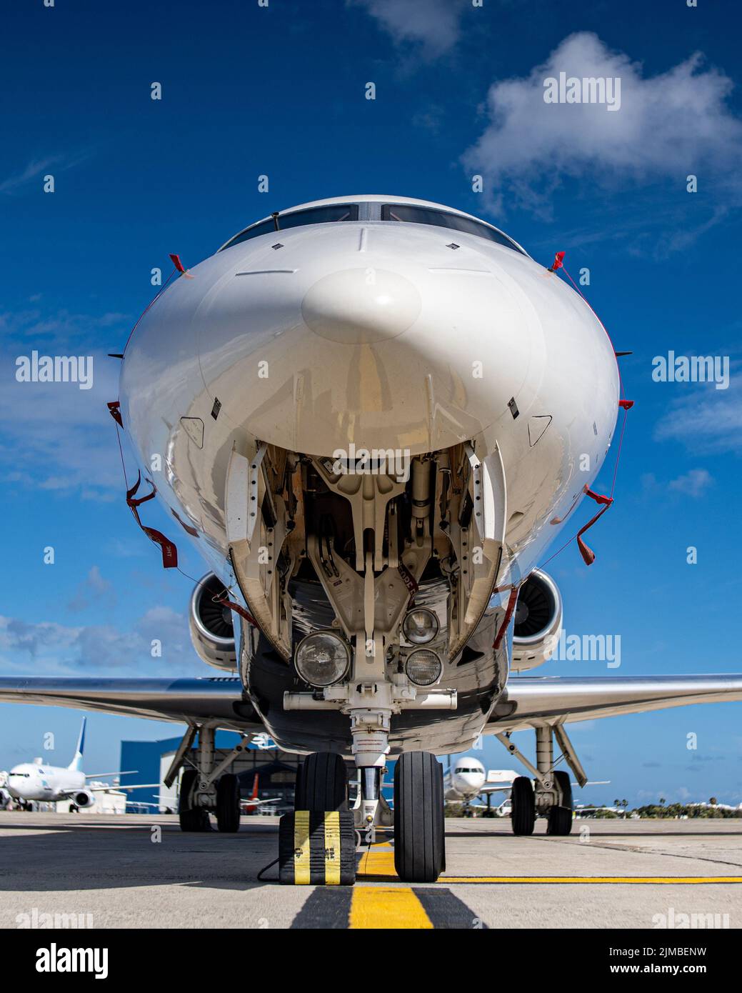 A low angle close-up view of landing gear under a big jet plane parked at the airport apron Stock Photo