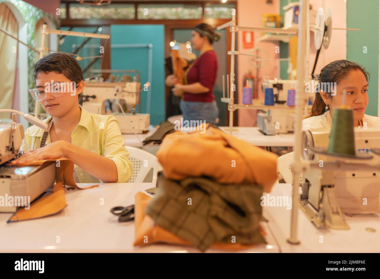 Three multiethnic women working in a sewing workshop Stock Photo