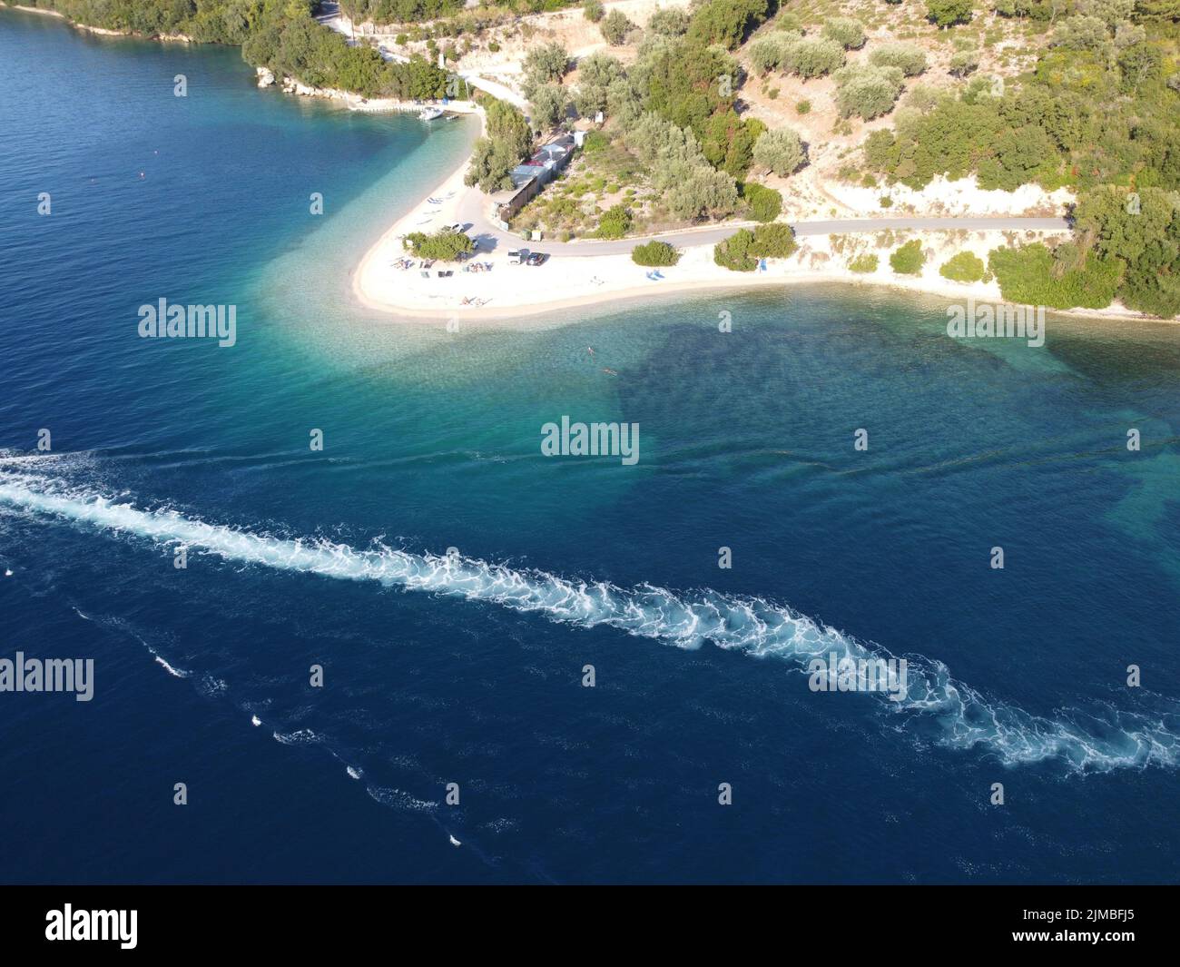An aerial view of the sandy beach of lush green island and blue ocean ...
