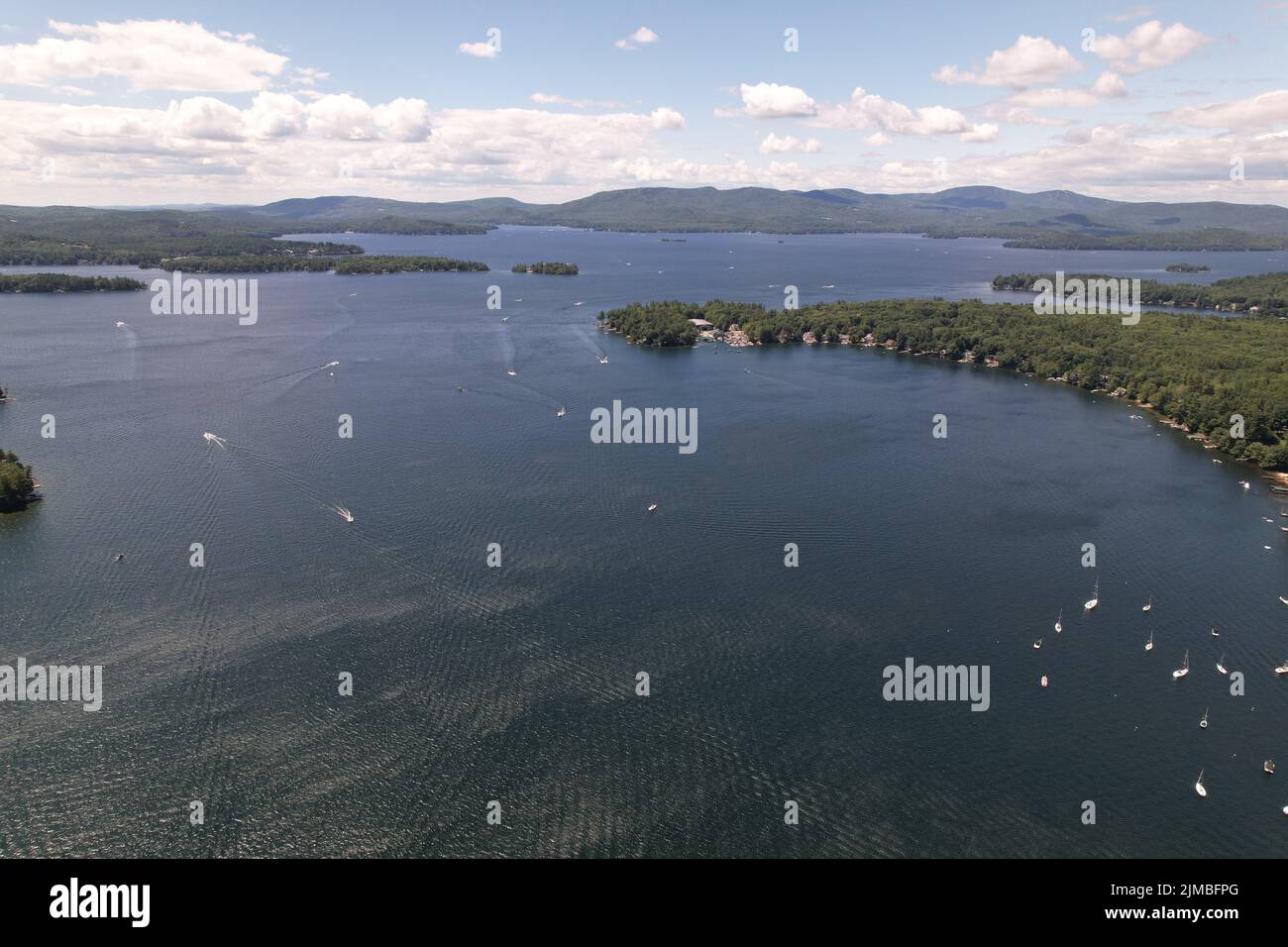 An aerial view of Newfound Lake, NH with boats on the water, trees and