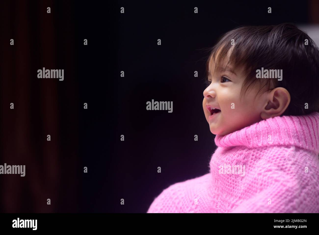A cute 13 months old Indian baby girl wearing a poncho Stock Photo
