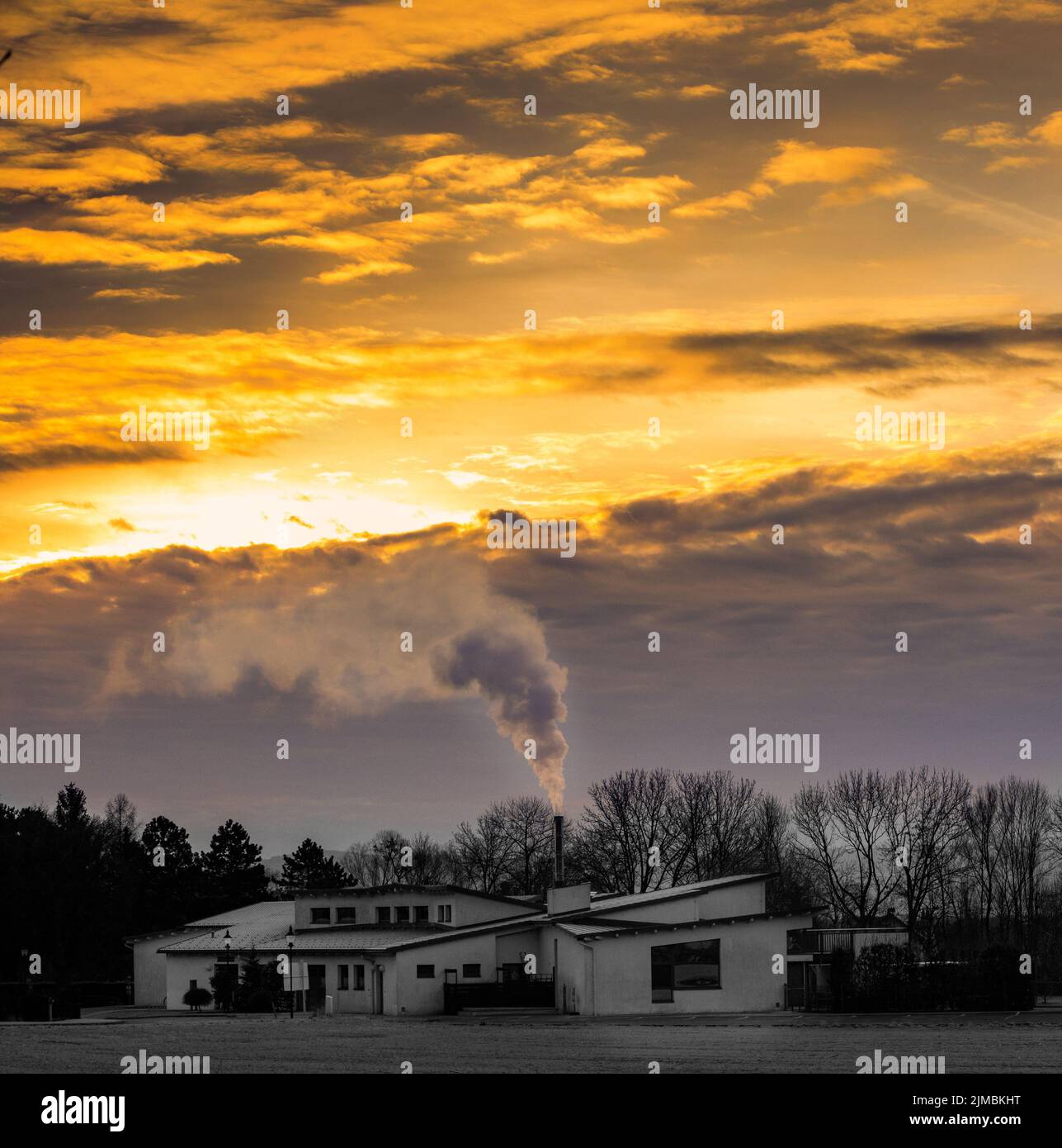 Fantastic landscape glowing by sunlight. Dramatic wintry scene with a house during the sunrise Stock Photo
