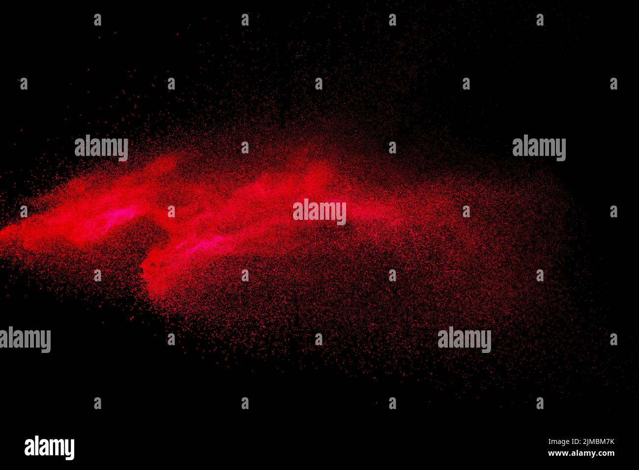Red color powder explosion on black background.Freeze motion of red