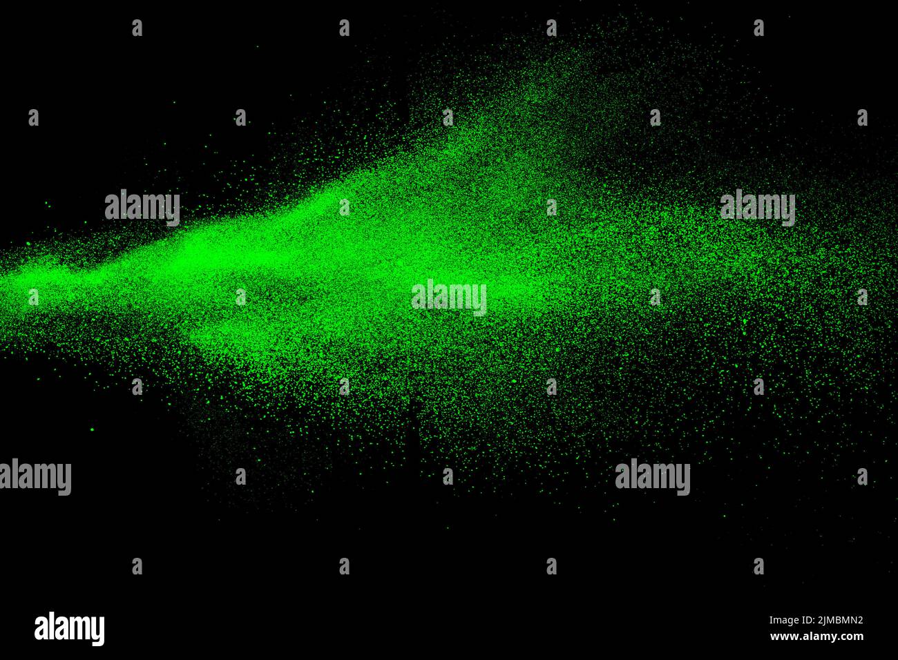 Green color powder explosion cloud on black background.Green dust