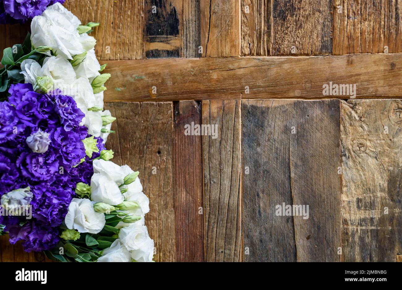 Purple and white contrasting flowers placed on wooden surface. Stock Photo