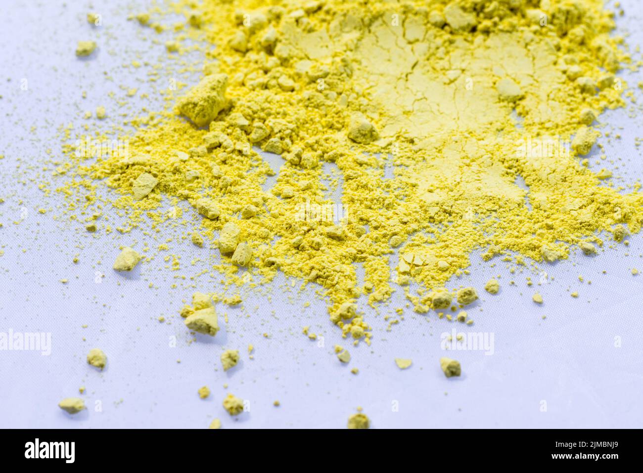 Yellow color background of chalk powder. Yellow color dust particles splattered on white background. Stock Photo