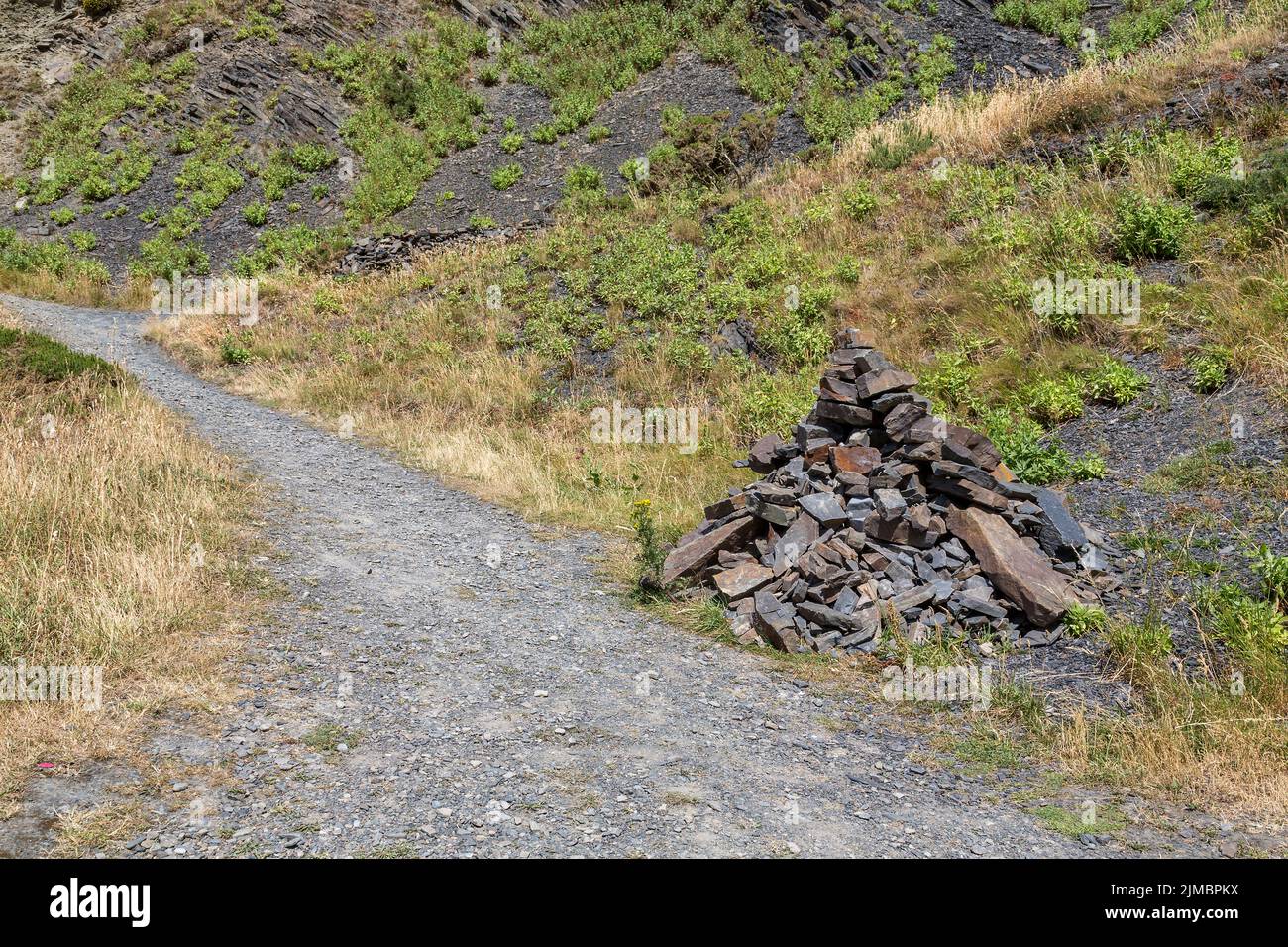 A pile of rocks or cairn is used to mark the path on a mountain or rough terrain.Health, fitness, walking, hiking or active leisure time concept. Stock Photo