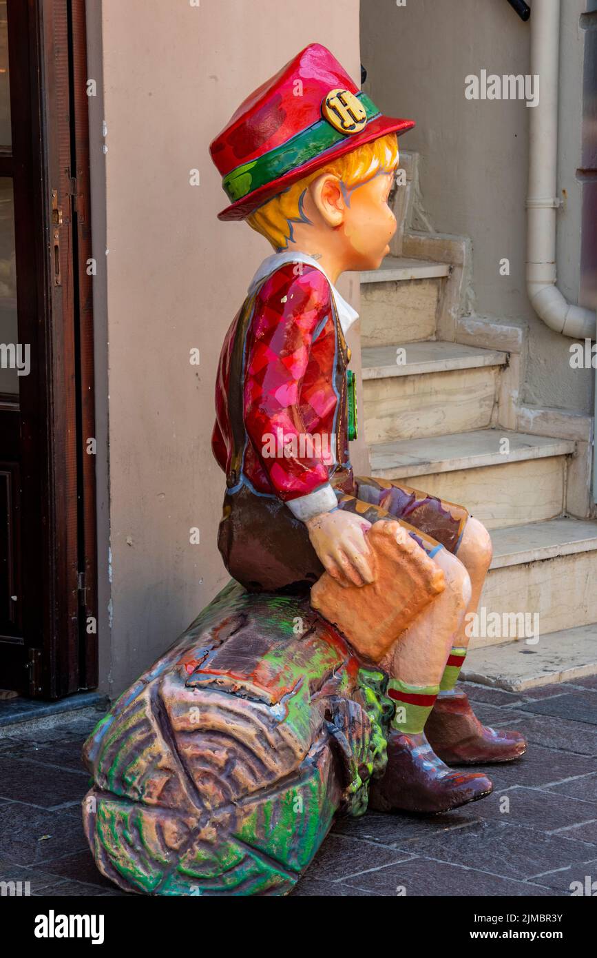 life-sized model of a bavarian german child in the form of pinochio or alpine chil, traditional german or austrian dress and costume represented model Stock Photo