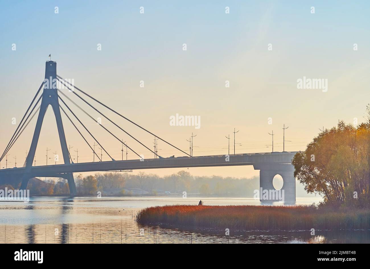 Enjoy the foggy autumn sunrise in Natalka Park on Dnieper River with hazy Pivnichnyi (Northern) Bridge in background, Kyiv, Ukraine Stock Photo
